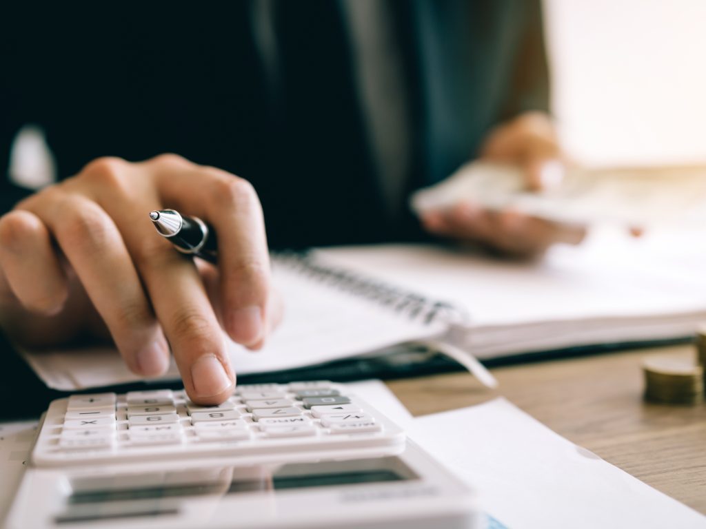 Person typing on a calculator