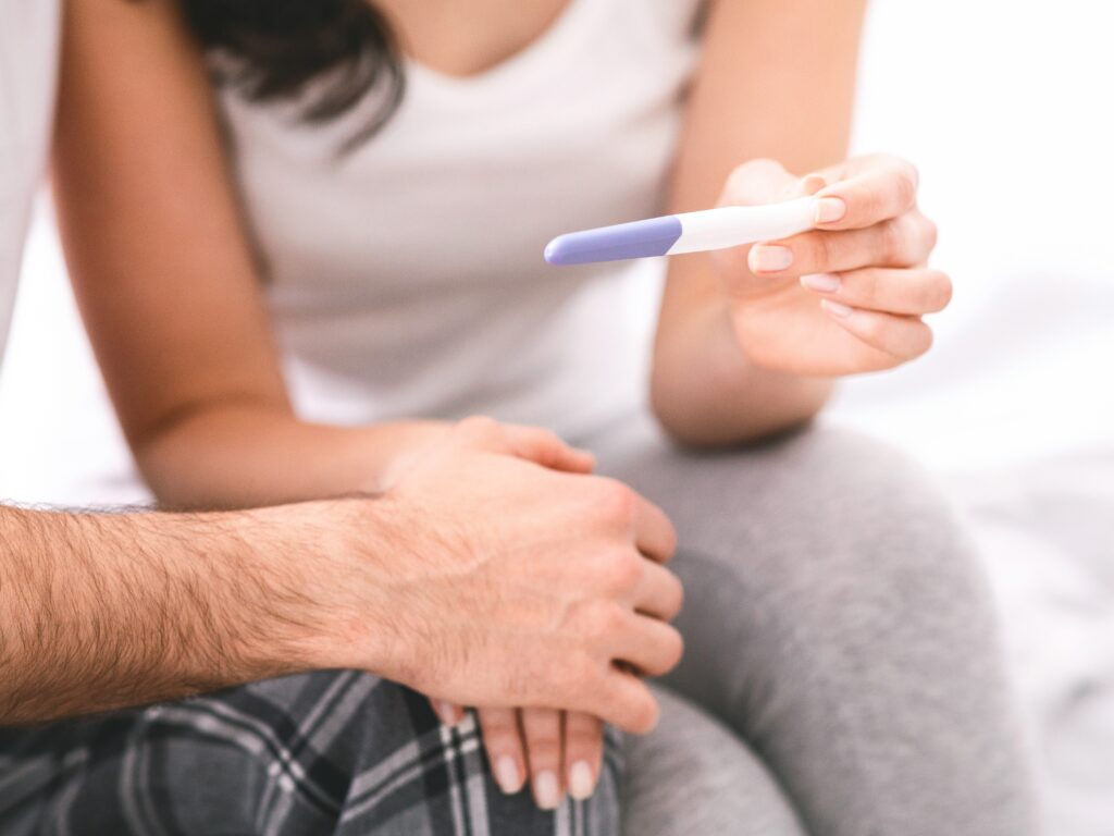 woman showing her partner a pregnancy test