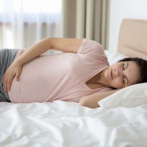 Pregnant woman lying on her side in bed